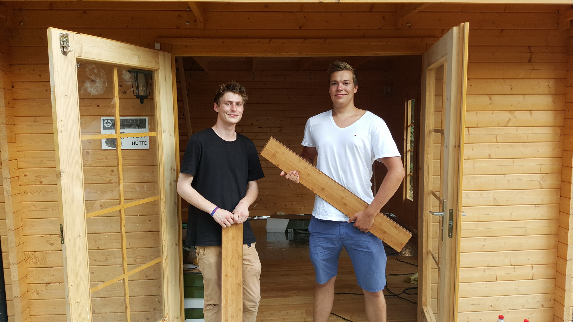 Pfadfinder Nicolas Naumann und Bufdi Hannes Vojtech verlegen Parkett in der "Pfadihütte" des Neudietendorfer Pfadfinderzentrums